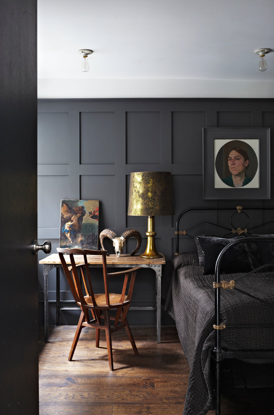Dunkles Schlafzimmer mit Wandvertäfelung im Farbton Railings No. 31 von Farrow & Ball